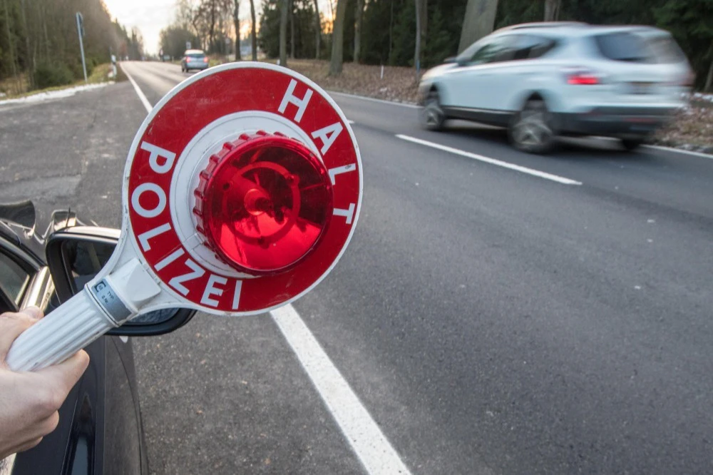 Polizei stoppt illegales Autorennen — © Ein Polizist hält eine Polizeikelle. Foto: Armin Weigel/Archiv