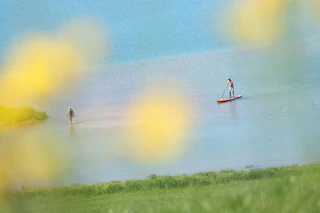 Ein SUP-Fahrer ist auf dem Forggensee unterwegs. (Archivbild) — © Karl-Josef Hildenbrand/dpa