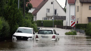 Autos stehen im Hochwasser der Mindel in einem Wohngebiet. — © Karl-Josef Hildenbrand/dpa