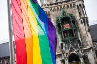 Als Zeichen der Solidarität wehen vor dem Münchner Rathaus Regenbogenflaggen. (Archivbild) — © Lino Mirgeler/dpa