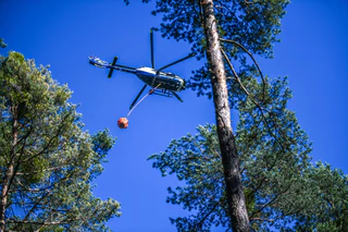 Die Feuerwehr versucht den Brand auch mit Löschhubschraubern zu bekämpfen. (Symbolbild) — © Jason Tschepljakow/dpa
