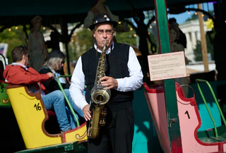 Gerne sorgt Toni Schleifer am Saxofon auch selbst für die passende Musik an seinem historischen Fahrgeschäft. — © Sven Hoppe/dpa