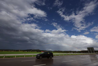 Zwischen Sommer- und Herbstwetter schmückt ein Regenbogen den Himmel über dem Allgäuer Alpenvorland. — © Karl-Josef Hildenbrand/dpa