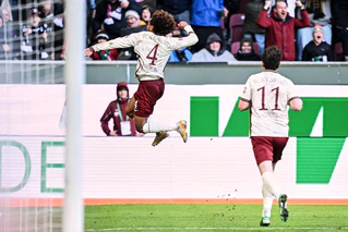 Han-Noah Massengo hebt nach seinem 1:0 jubelnd ab - zum Sieg reichte sein Kopfballtor für den FC Augsburg aber nicht.  — © Harry Langer/dpa