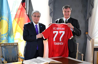 Ein Trikot als Geschenk: Markus Söder empfängt den Präsidenten Kasachstans. — © Felix Hörhager/dpa