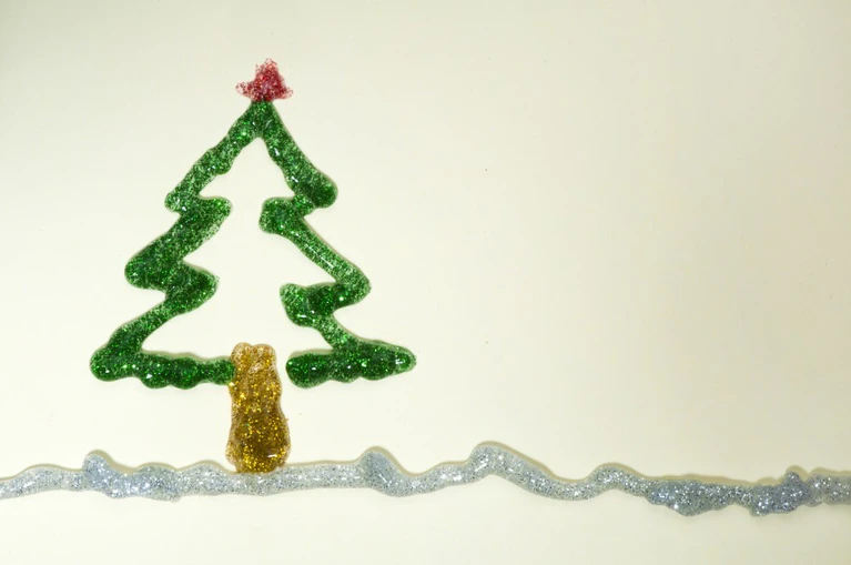 — © Christmas tree made of shiny gel over white paper. Copy spice