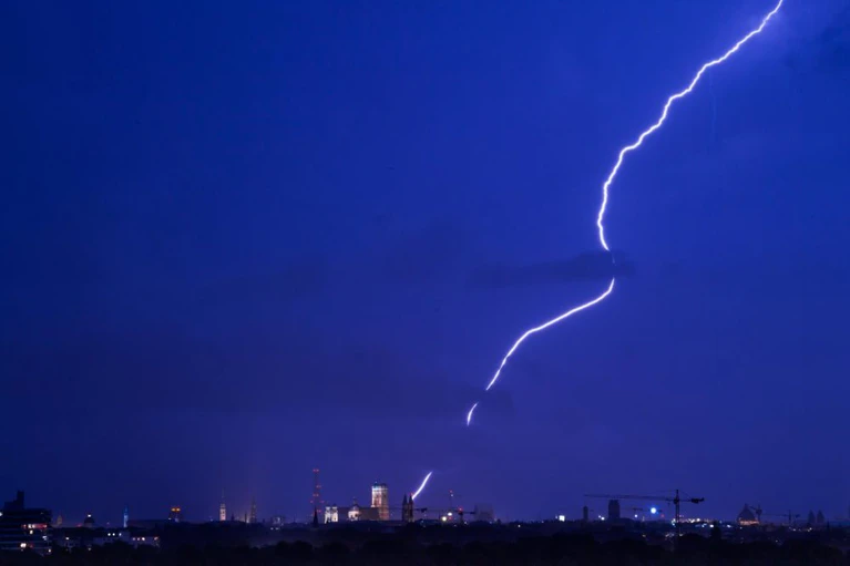 Gewitter, Hagel — © Ein Blitz zuckt über der Skyline von München. Foto: Peter Kneffel/Archiv