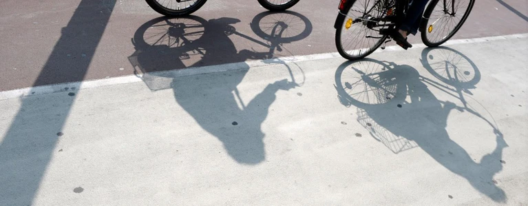 Radentscheid, Bürgerbegehren, Radl-Offensive — © Radfahrer werfen Schatten auf einem Fahrradweg. Foto: Ronald Wittek/Archiv