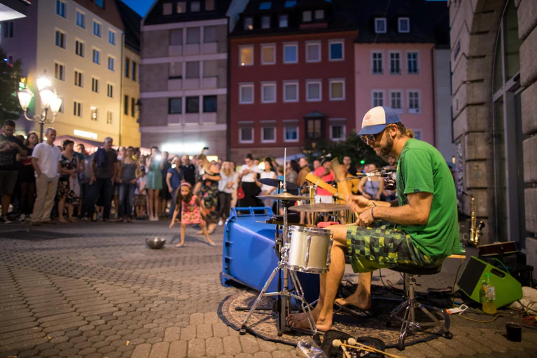 Straßenmusiker — © Ein Straßenmusiker spielt auf einem Schlagzeug, das zum Teil aus einer Mülltonne besteht. Foto: Daniel Karmann/Archivbild