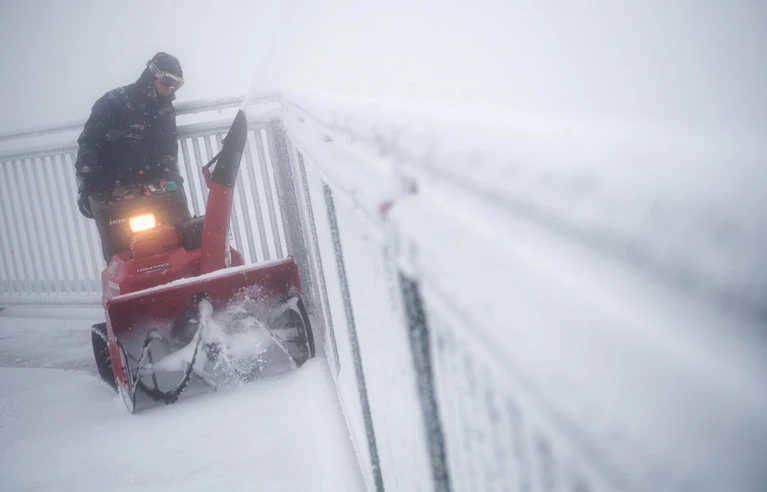 Zugspitze — © Ein Mann fährt mit einem Schneepflug auf dem Gipfel der Zugspitze über die Aussichtsplattform. Foto: Sven Hoppe/Archivbild