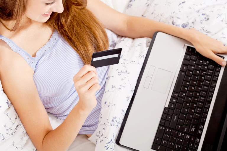 Online, Onlineshopping, Shopping, Frau, Bett, Laptop — © Bild: Symbolbild