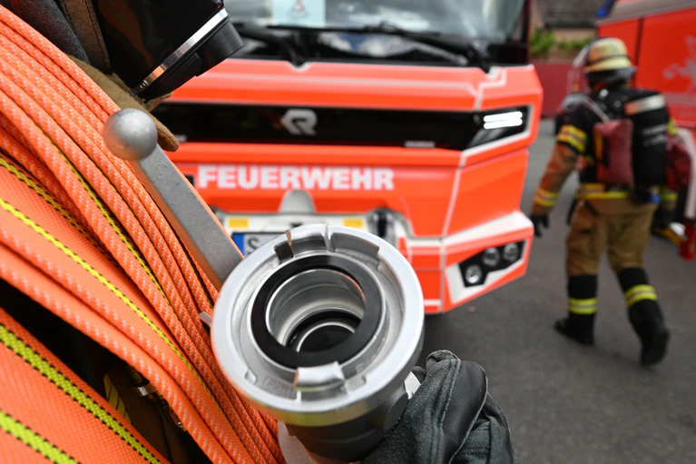 Feuerwehrleute waren in der Nacht noch mit dem Löschen der Lagerhalle beschäftigt. (Symbolbild) — © Bernd Weißbrod/dpa