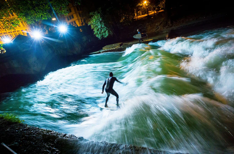 Bis vor kurzem sah die Eisbachwelle noch so aus und begeisterte Surfer aus aller Welt. (Archivbild) — © Peter Kneffel/dpa