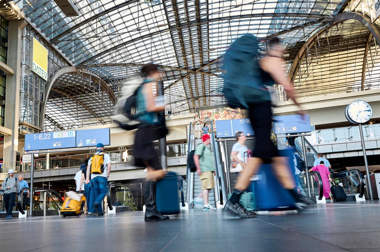 Mit Kaffee oder Koffer in der Hand geht es in Berlin am Morgen entspannt zu. — © Michael Ukas/dpa