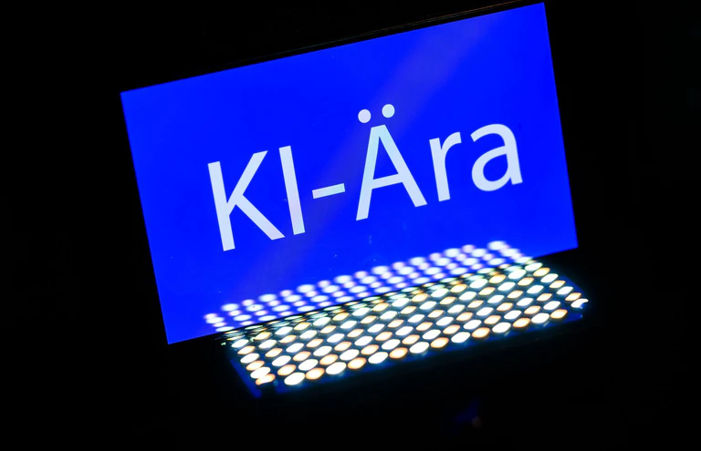 Das Wort des Jahres 2025 ist «KI-Ära». Voraussichtlich 2026 werden viele Verbraucherinnen und Verbraucher erstmals einer Weiterentwicklung der Technologie begegnen - beim Online-Einkauf. (Symbolbild)  — © Robert Michael/dpa