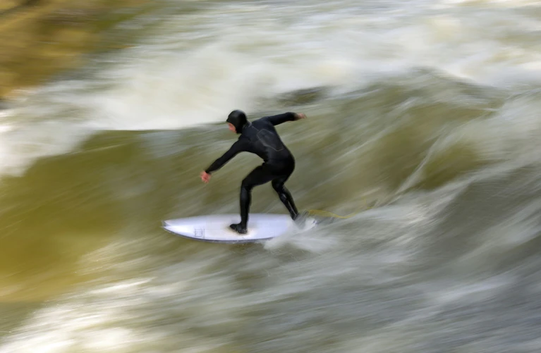 Die Surferinnen und Surfer auf der Eisbachwelle zählen inzwischen als Attraktion in München. (Archivbild) — © Malin Wunderlich/dpa