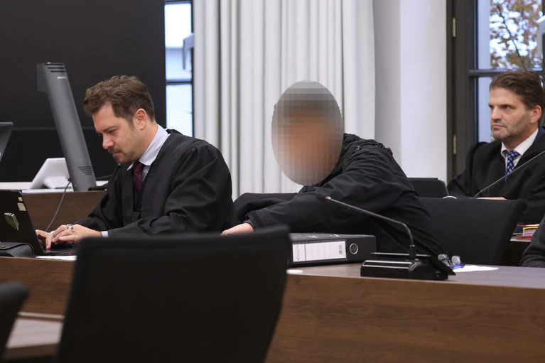 Der Angeklagte sitzt zwischen seinen beiden Rechtsanwälten im Gerichtssaal. — © Karl-Josef Hildenbrand/dpa