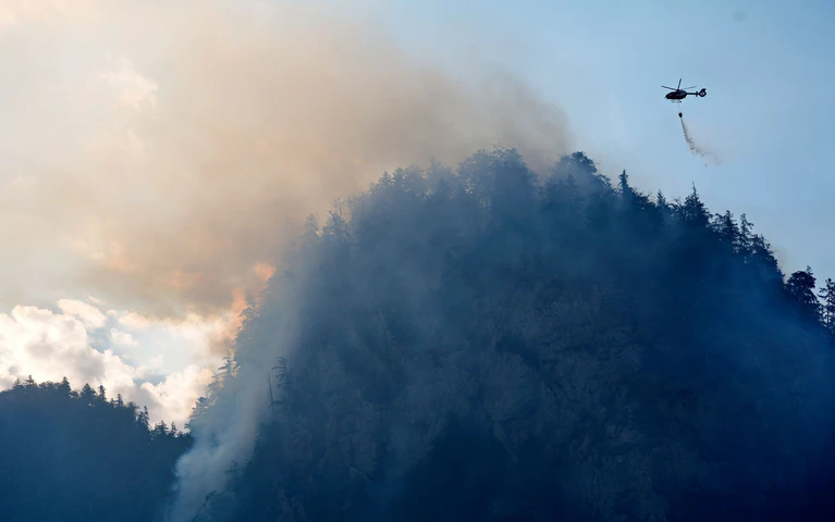Die Feuerwehr versucht den Brand auch mit Löschhubschraubern zu bekämpfen. — © Uwe Lein/dpa