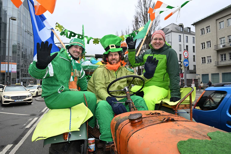 Auf einem Traktor nahmen diese Männer an der Parade der irischen Gemeinschaft teil.  — © Felix Hörhager/dpa