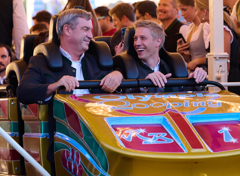 Hatten gemeinsam Spaß in der Achterbahn: Bayerns Ministerpräsident Markus Söder (CSU/l) und Münchens Oberbürgermeister Dominik Krause (Bündnis 90/Die Grünen)   — © Sven Hoppe/dpa