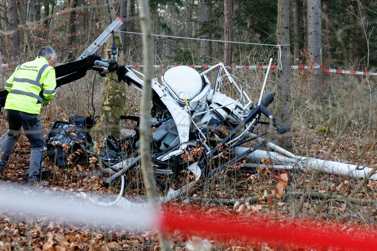 Ein Ermittler untersucht das Wrack an der Unfallstelle im Wald. — © Daniel Karmann/dpa